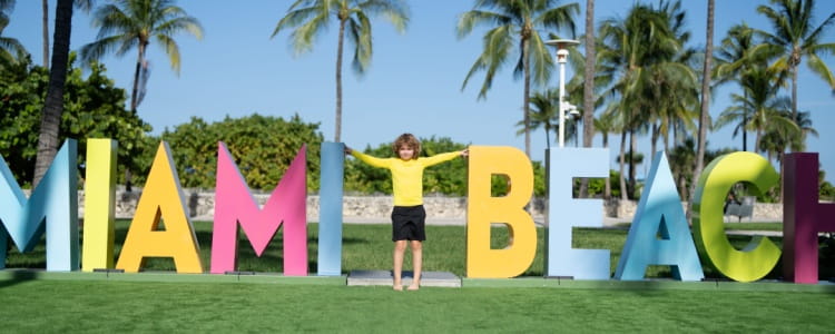 Child at colorful Miami Beach sign